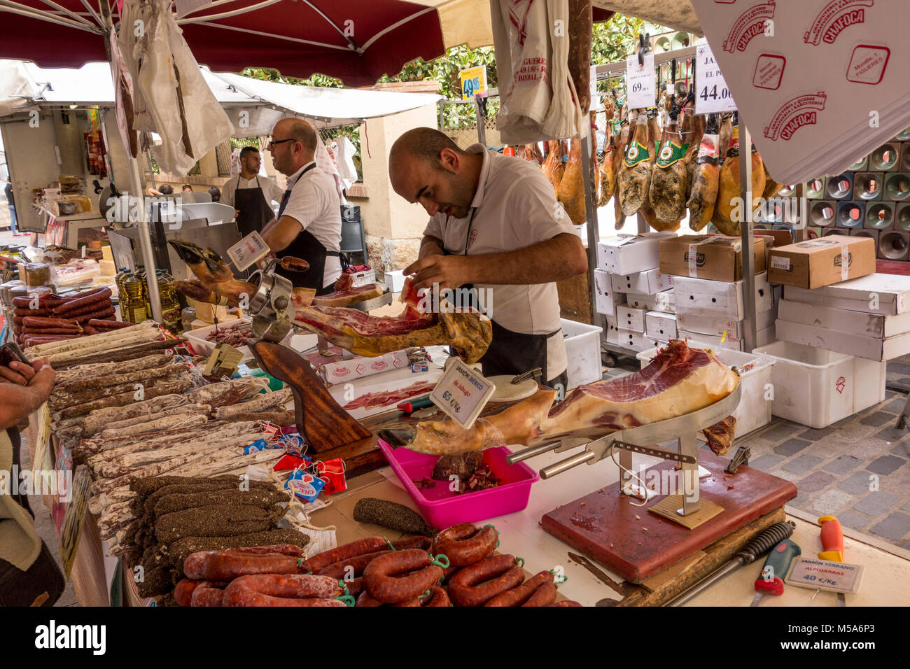 Ein stall Inhaber slicing Iberico Schinken am Wochenmarkt in La Bisbal d'Emporda, Baix Emporda, Katalonien, Spanien Stockfoto