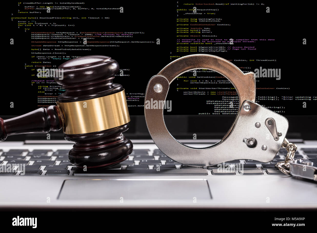 In der Nähe von Handschellen und Hammer Vor Laptop Bildschirm Stockfoto