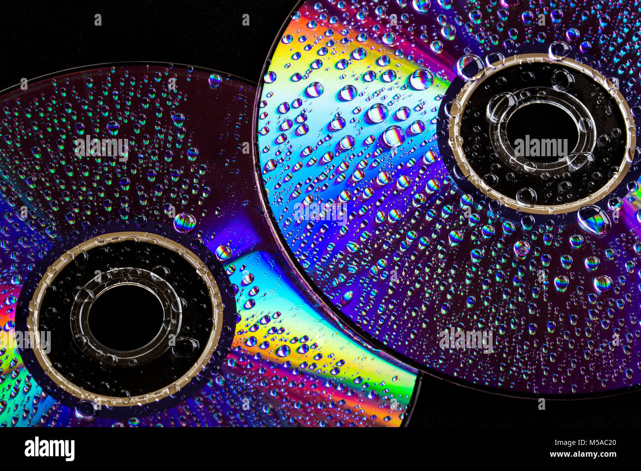 Ein paar CD's für einige "leichte" Musik. Wassertropfen und buntes Licht Spektrum auf dem glänzenden Oberflächen der Scheiben reflektiert Stockfoto