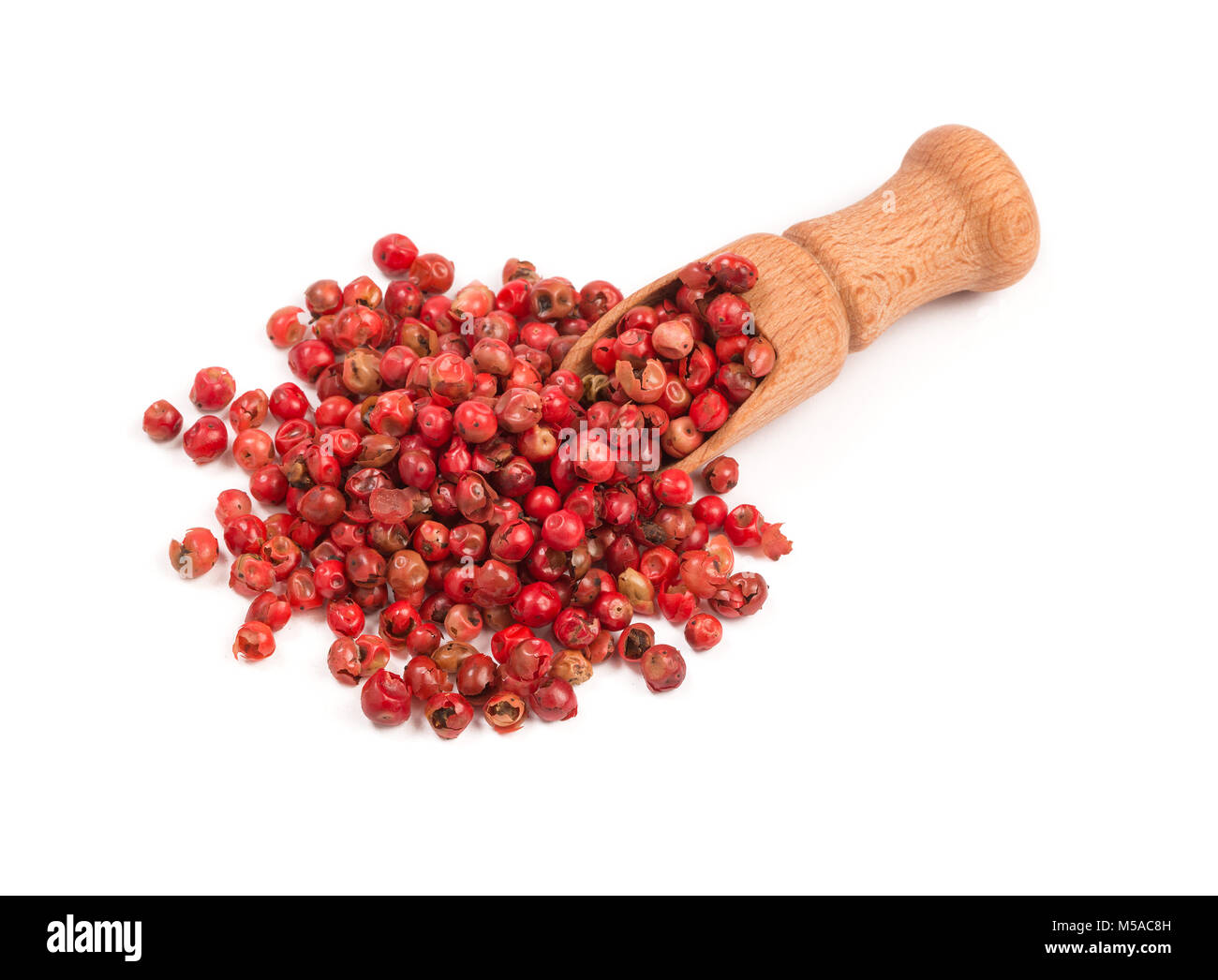 Rosa Pfeffer, Rote Pfefferkörner in einem Löffel aus Holz. Stockfoto