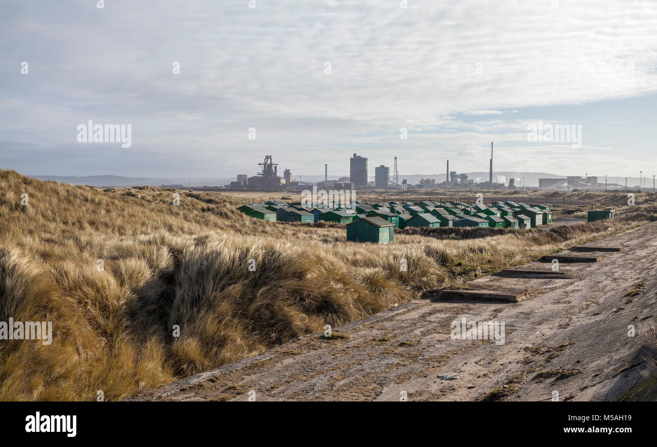 Die fishermens Hütten am South Gare, Redcar, England, UK mit der ehemaligen SSI Stahlwerk im Hintergrund Stockfoto