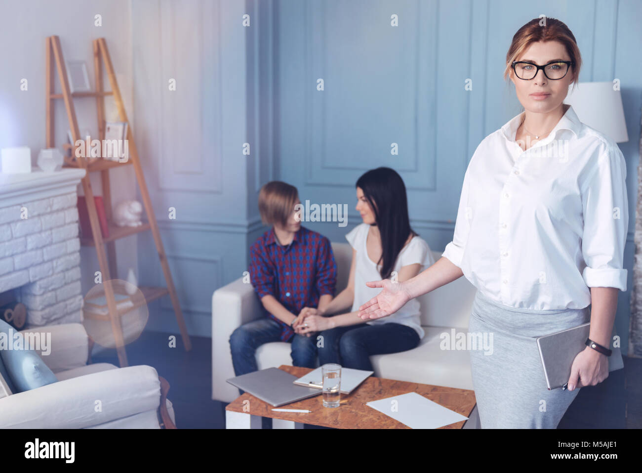 Weiblichen professionellen Psychologe mit liebevollen Familie im Hintergrund posiert Stockfoto