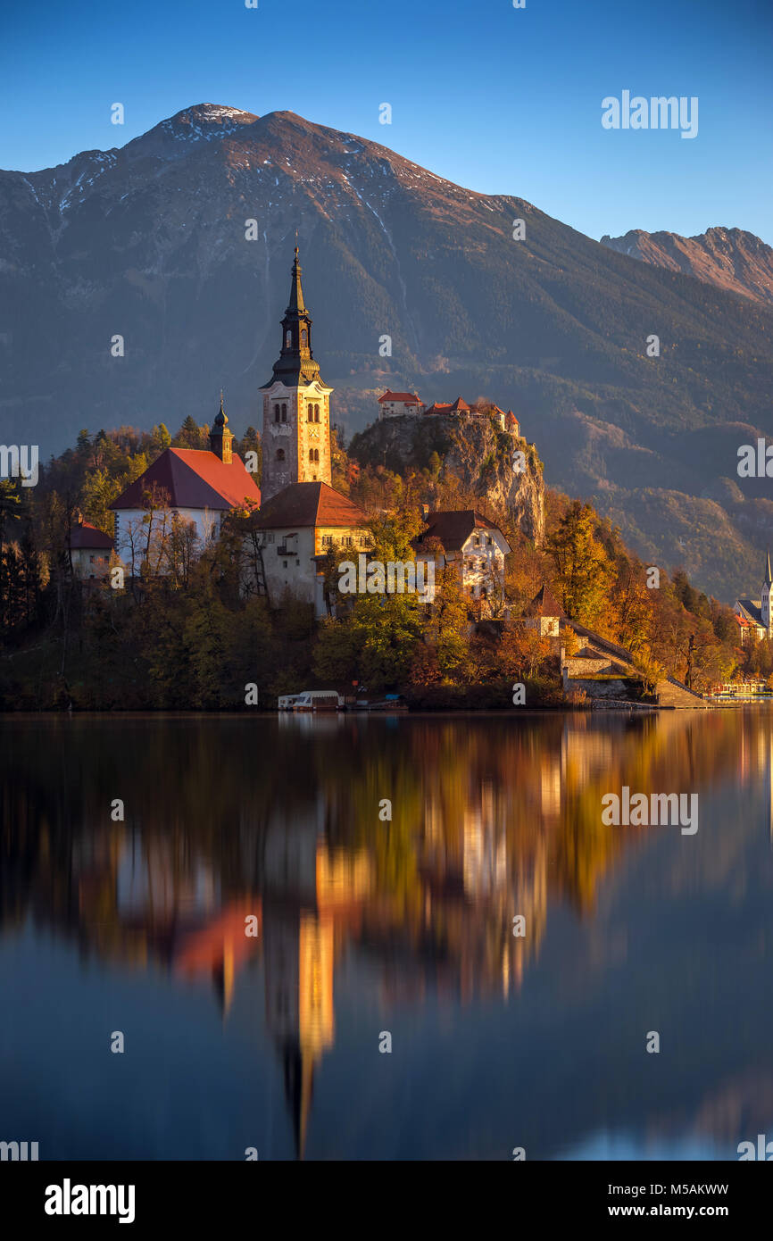 Bled, Slowenien - Bled an einem schönen Herbstmorgen mit der berühmten Wallfahrtskirche Mariä Himmelfahrt der Maria und die Burg von Bled und die Julischen Alpen Stockfoto