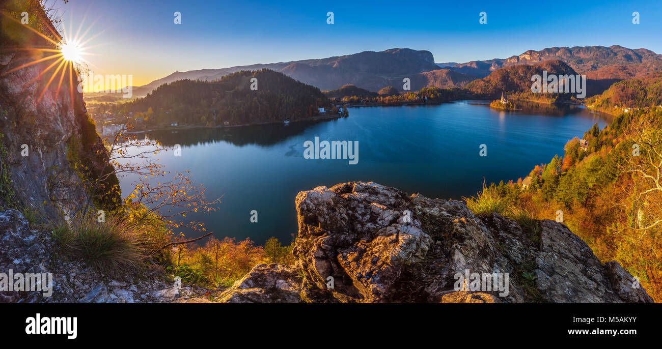 Bled, Slowenien - Schöne Herbst Sonnenaufgang am Bleder See auf einer Panorama-aufnahme mit Wallfahrtskirche Mariä Himmelfahrt der Maria und Alpen am backgroun Stockfoto