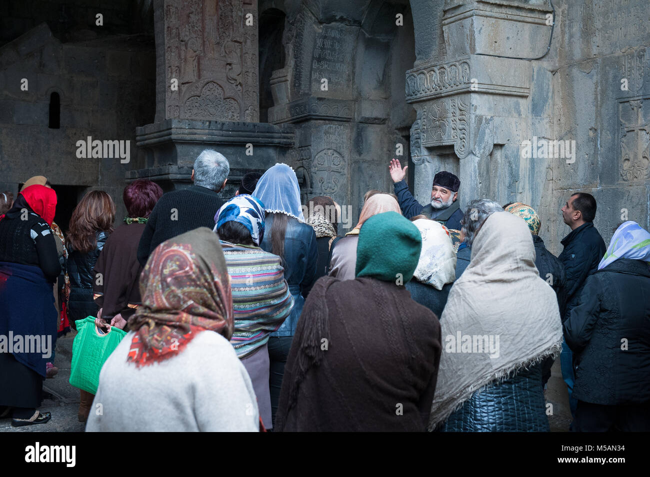 Tourguide erklärt die Bedeutung der Khachkar mit Kreuz im Kloster Haghpat. Stockfoto