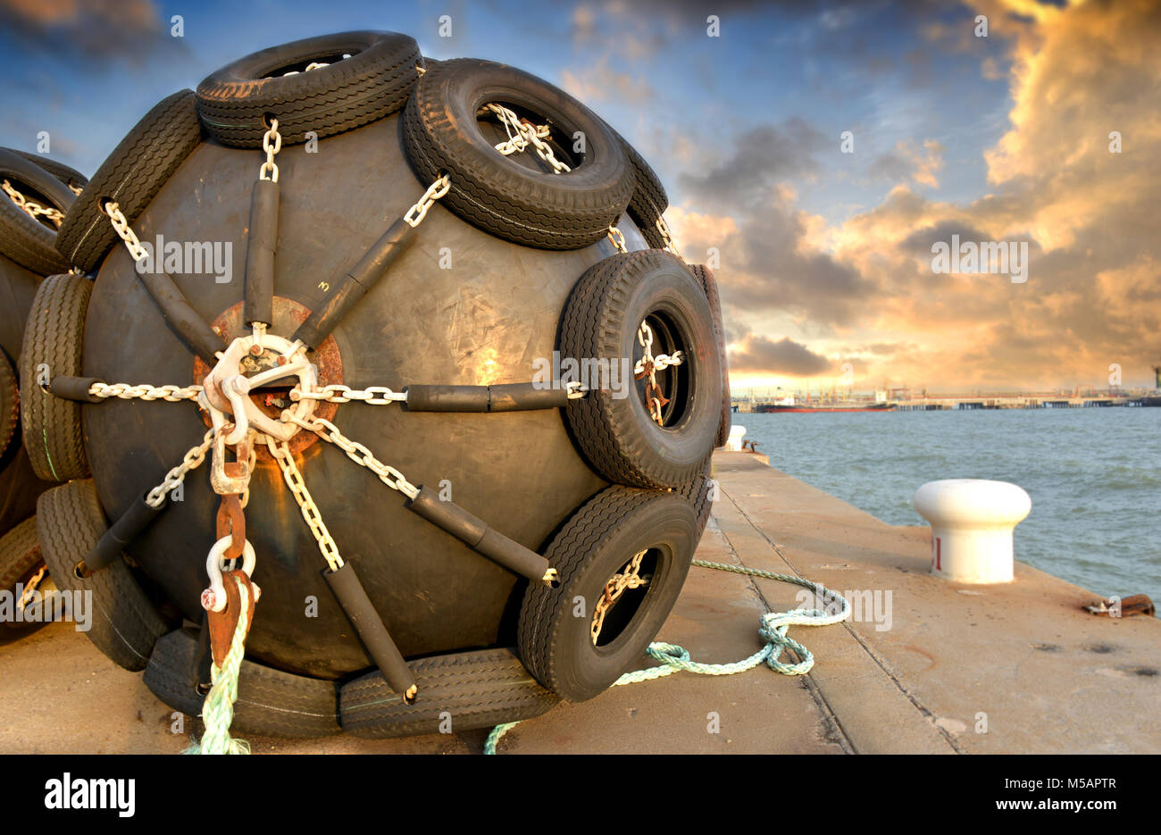 Das große Schiff schutz Gummi Schwimmer Boje auf der Cargo port Foto in einen Sonnenuntergang und warmer Beleuchtung. Stockfoto