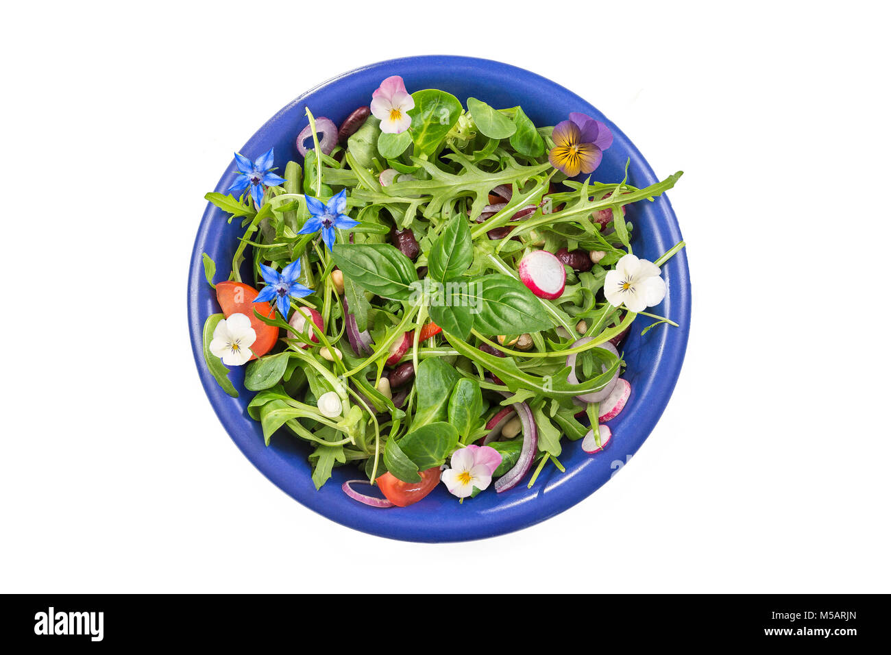 Frische Kraut Salat mit Blattgemüse und kapuzinerkresse Blumen in einem blauen Keramik Schüssel auf weißen serviert. Stockfoto