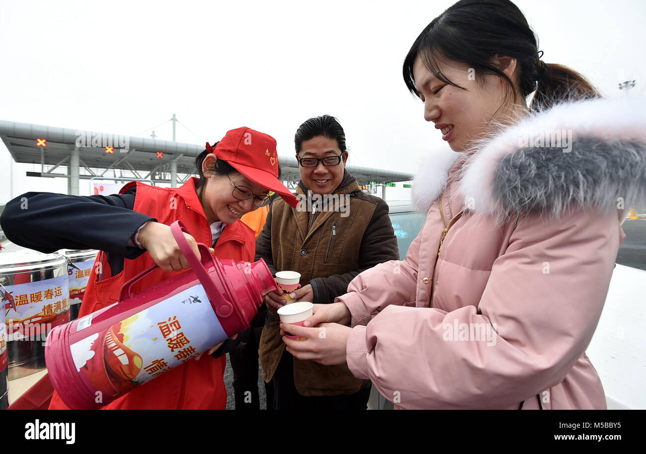 Yangzhou, China Jiangsu Provinz. 21 Feb, 2018. Ein freiwilliger liefert warmes Wasser für die Fahrgäste an shugang Mautstation in Yangzhou, Osten Chinas in der Provinz Jiangsu, Feb 21, 2018. Steigende reisen am Mittwoch gezeugt wurden, ist der letzte Tag der Woche - lange chinesische Mondjahr Urlaub, als Menschen wieder von ihrer Heimatstadt zu arbeiten. Credit: Zhuang Wenbin/Xinhua/Alamy leben Nachrichten Stockfoto