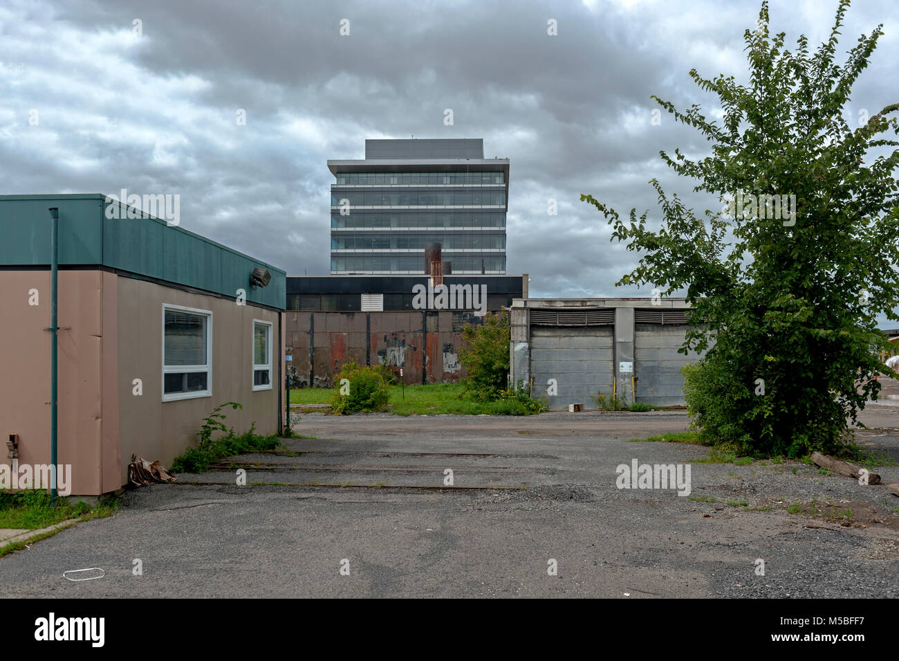 Neuere Glasturm ist Hintergrund für flaches Ältere kommerzielle Gebäude Stockfoto