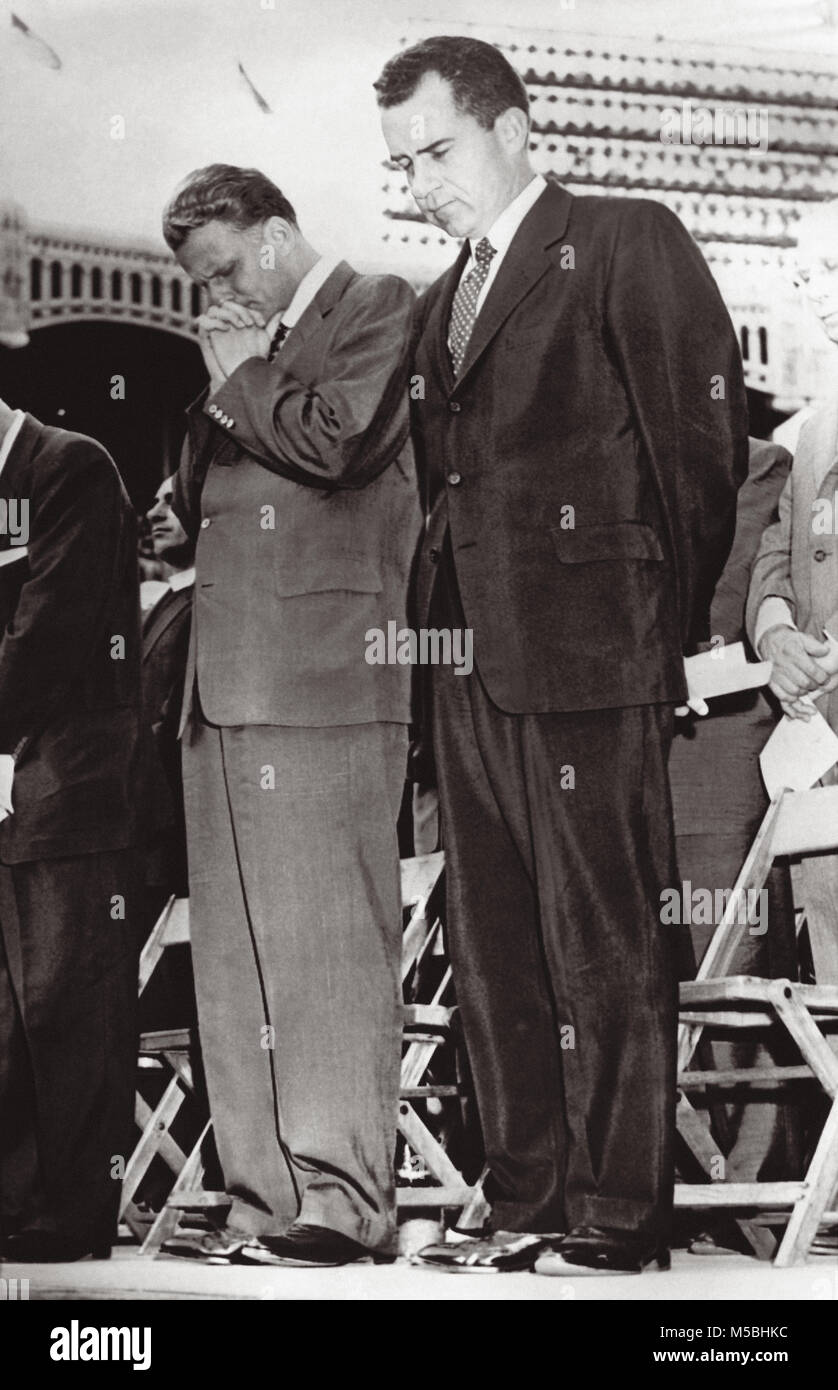 Evangelist Billy Graham und Vice President Richard Nixon bug Köpfe im Gebet während dem Höhepunkt der evangelistischen Billy Grahams sammeln Juli 20, 1958 im Yankee Stadium in New York City mit schätzungsweise 85.000 Menschen im Stadion und anderen 2500 außerhalb der Ballpark. Stockfoto