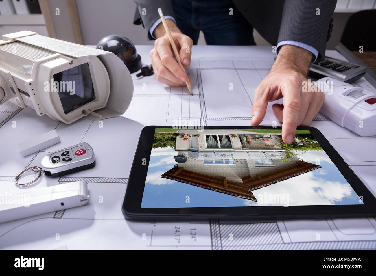 In der Nähe von Hand und mit Hilfe eines Architekten digitale Tablet während des Zeichnens Plan auf Blueprint Stockfoto