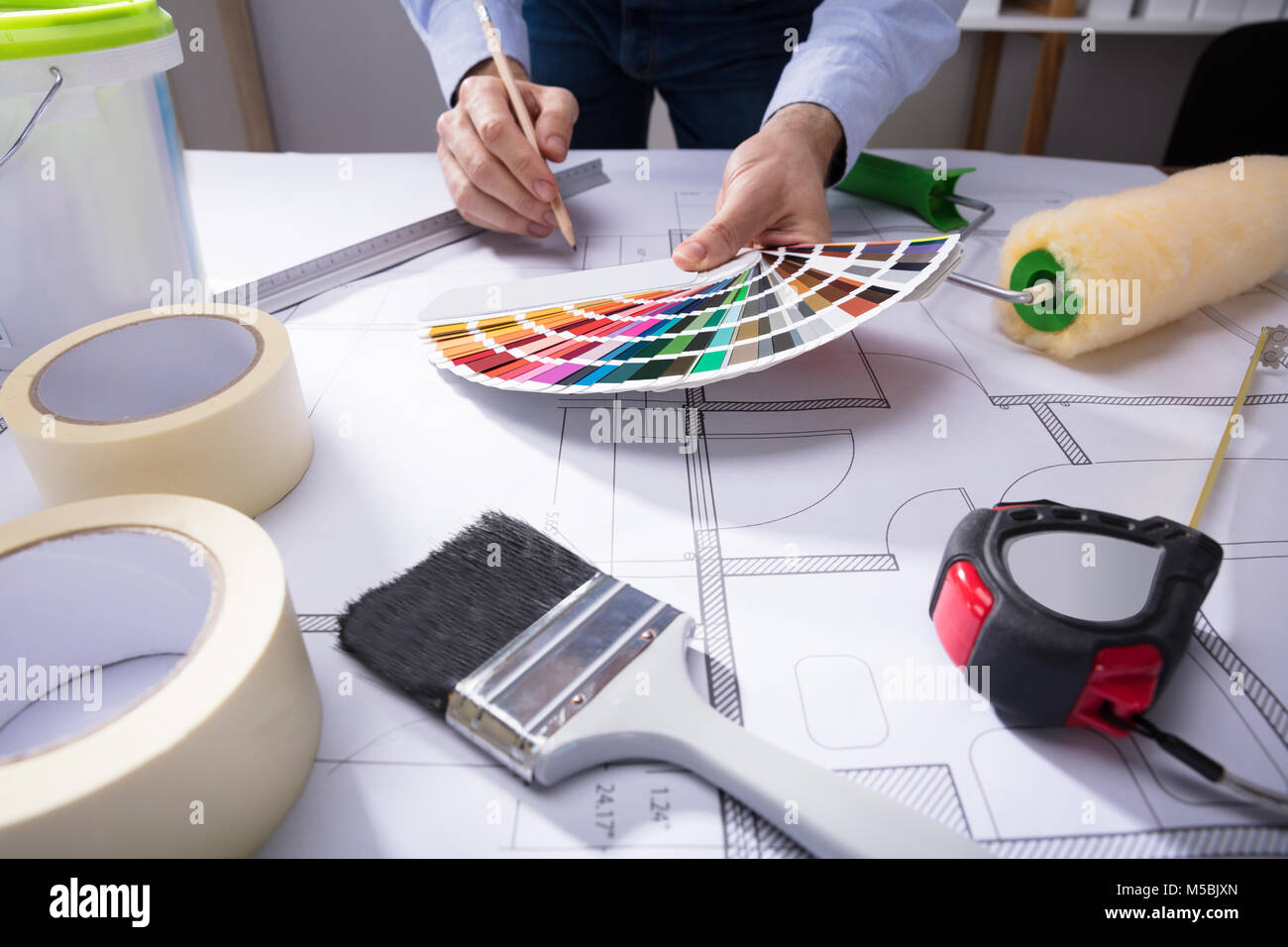 Der Architekt von Hand mit Farbe Guide Swatch während des Zeichnens Plan auf Blaupause mit Bleistift Stockfoto