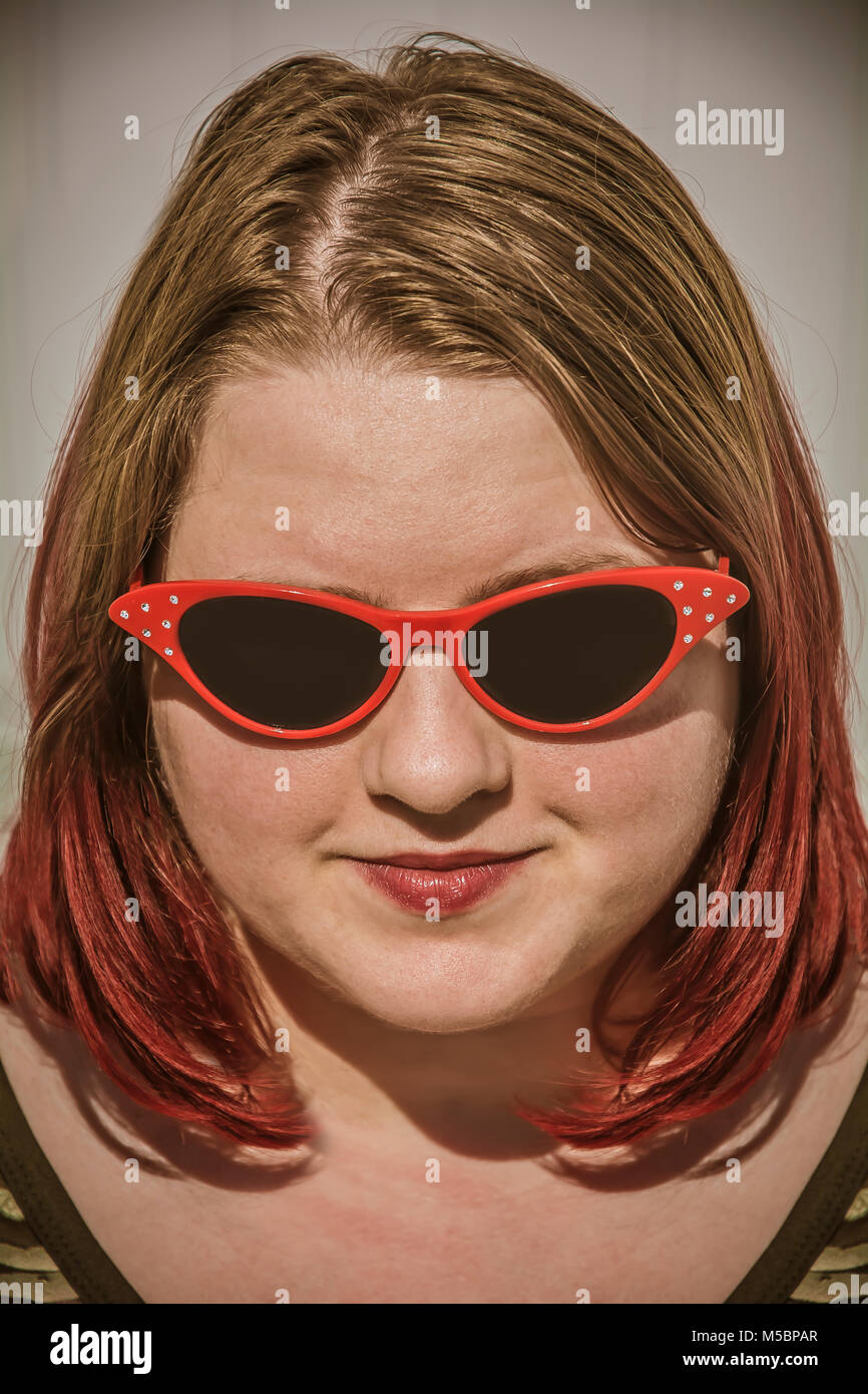 Hübsches Mädchen mit gefärbten Haaren tragen rote Sonnenbrille Stockfoto