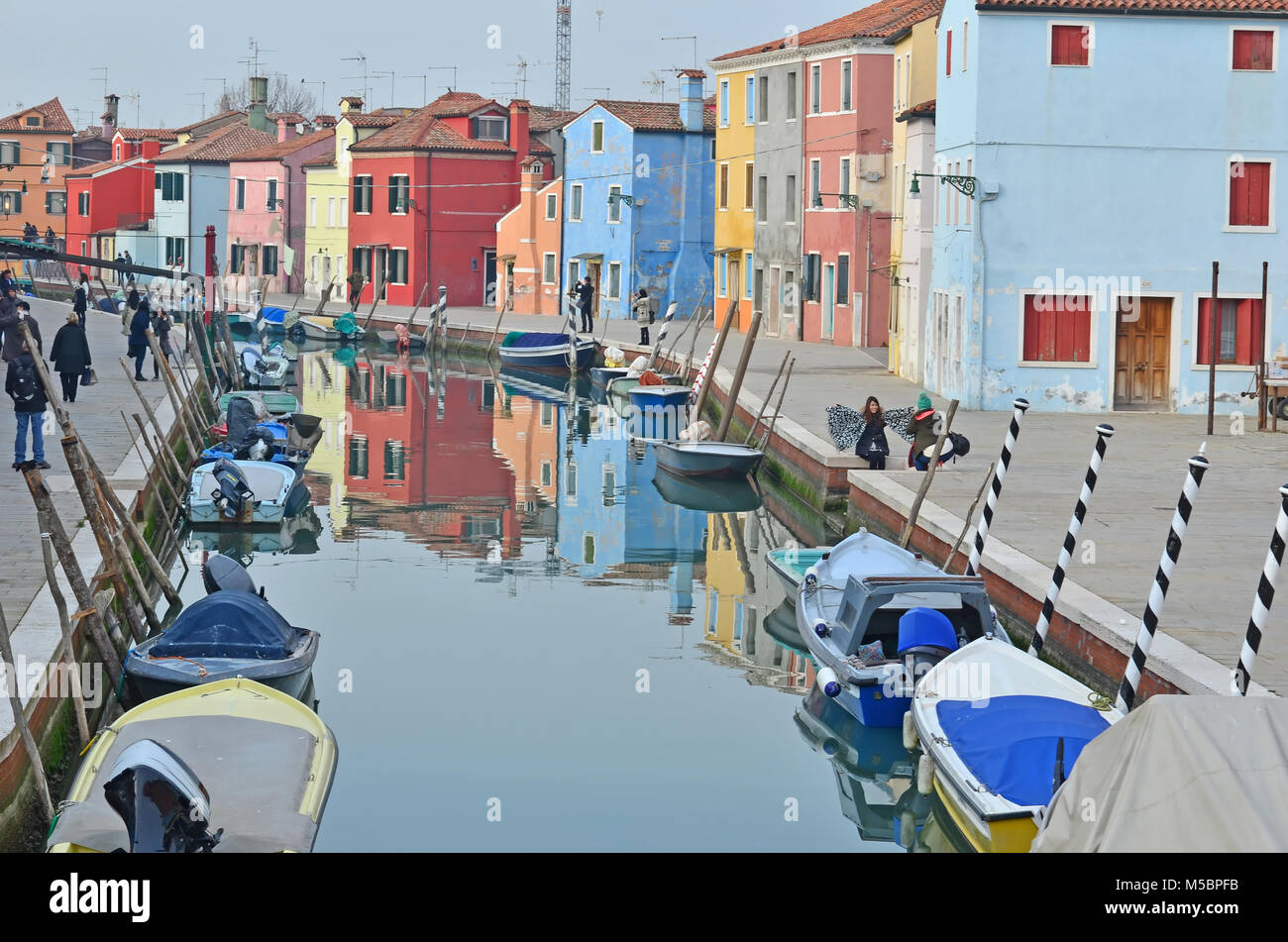 BURANO, ITALIEN - Januar 27: Touristen genießen die bunten Häuser entlang des Kanals auf der schönen Insel Burano: Januar 27, 2016 in Burano, Italien Stockfoto