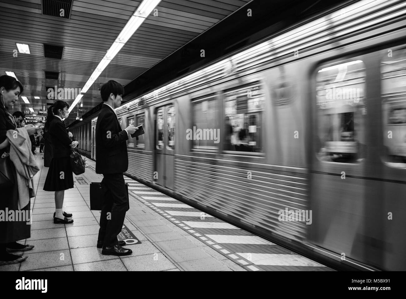 Pendler warten auf der Plattform als der Zug kommt Stockfoto