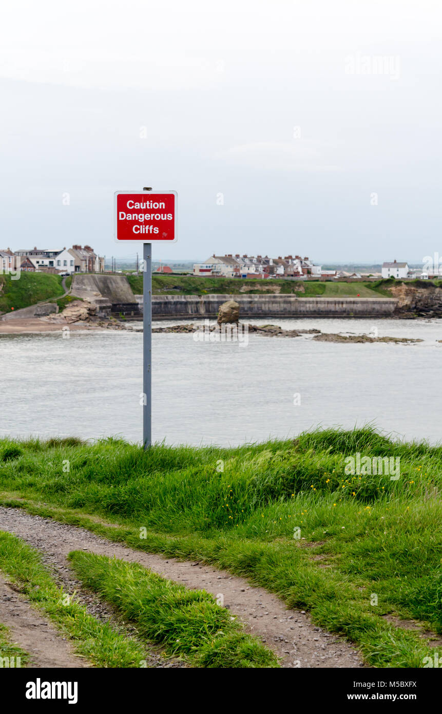 'Achtung gefährliche Klippen" Warnschild auf der Klippe am Collywell Bay, Seaton Sluice, Northumberland Stockfoto