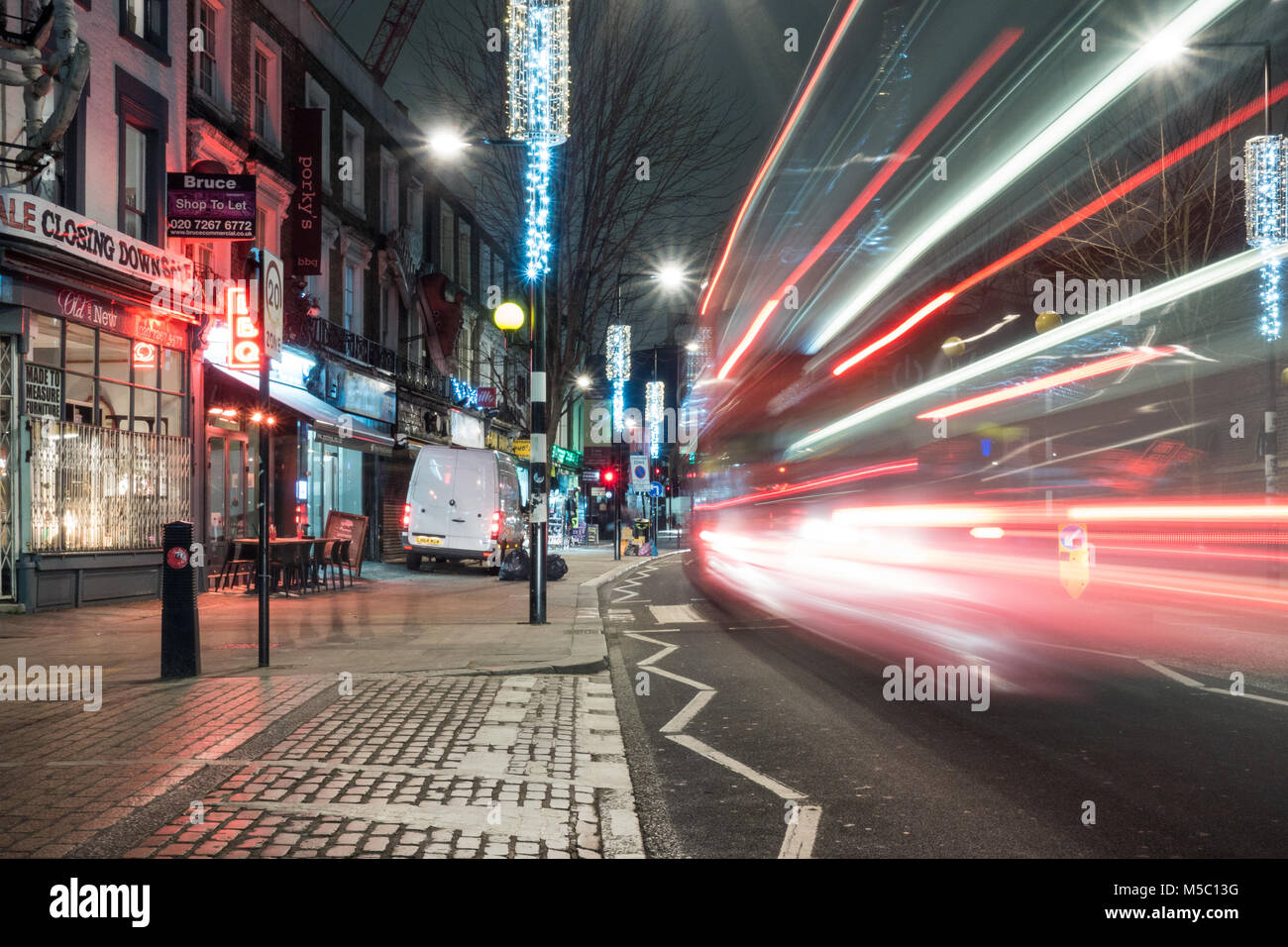 London, England, Großbritannien - 8. Januar 2018: Ein roter Doppeldeckerbus London Bus bewegt sich entlang der Chalk Farm Road in Camden Town, nördlich von London, in der Nacht. Stockfoto