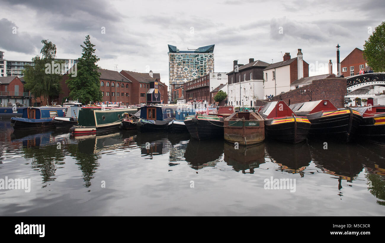 Birmingham, England, UK - 23. Juni 2012: Traditionelle narrowboats und Lastkähne sind im Regency Wharf auf der Birmingham Canal festgemacht, mit dem Würfel bei Mail Stockfoto