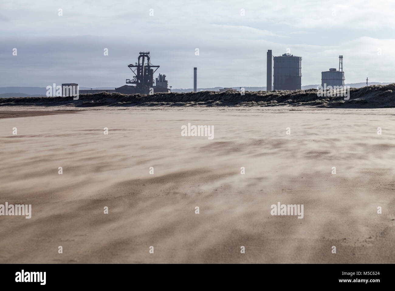 Redcar Strand in einem Sandsturm mit der ehemaligen SSI Stahlwerk im Hintergrund Stockfoto