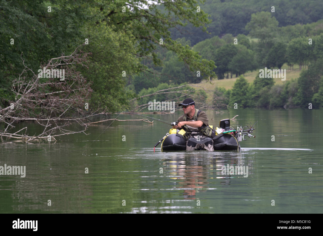 Angeln mit einem float Tube. Der Mann sitzt im Angeln Schlauchboot und er mit Flossen auf dem Wasser zu bewegen. Stockfoto