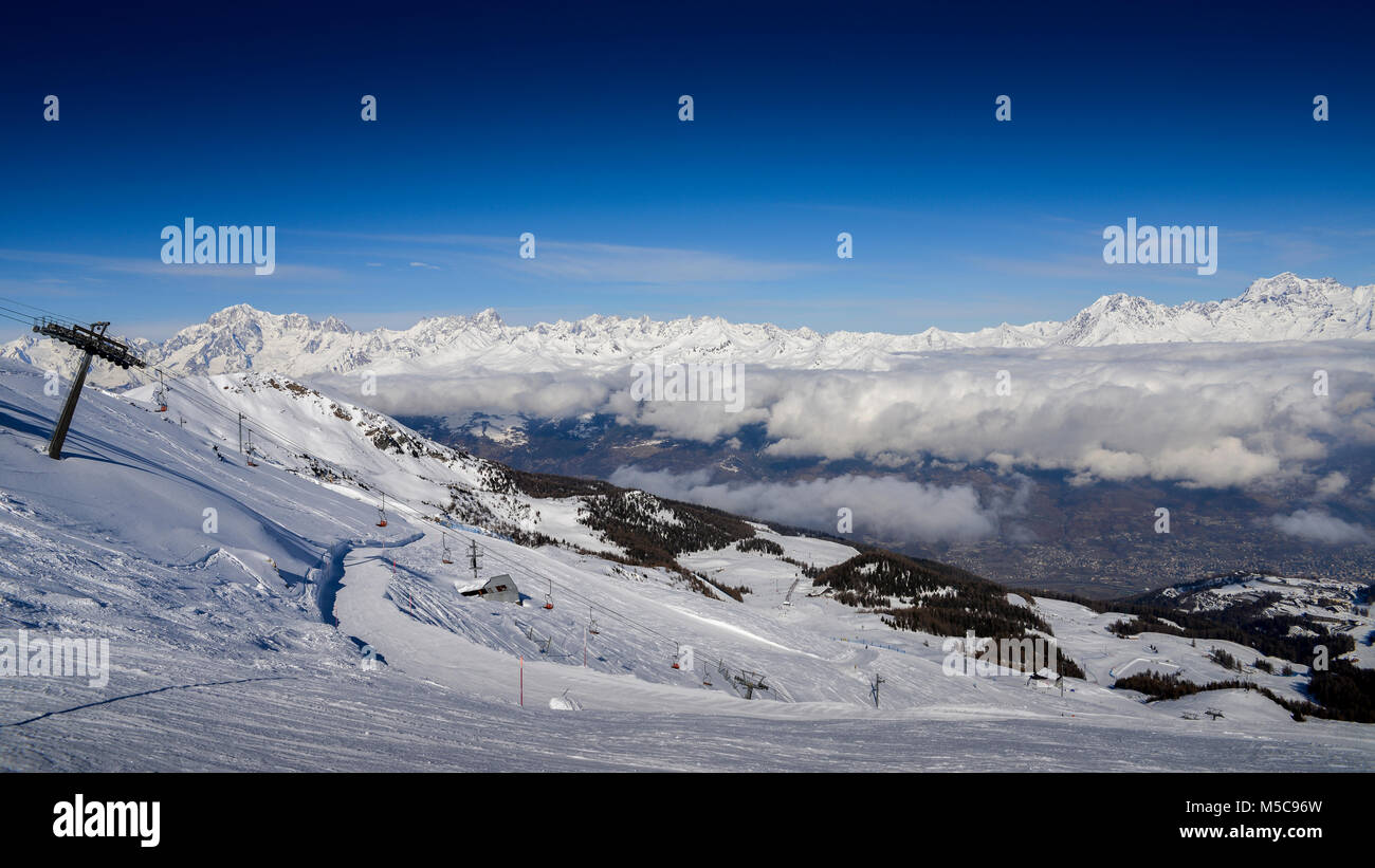 Sesselbahn am italienischen Skigebiet Pila auf schneebedeckten Alpen und Pinien im Winter mit Mt. Blanc in Frankreich im Hintergrund sichtbar Stockfoto Sesselbahn am italienischen Skigebiet Pila auf schneebedeckten Alpen und Pinien im Winter mit Mt. Blanc in Frankreich im Hintergrund sichtbar Stockfoto