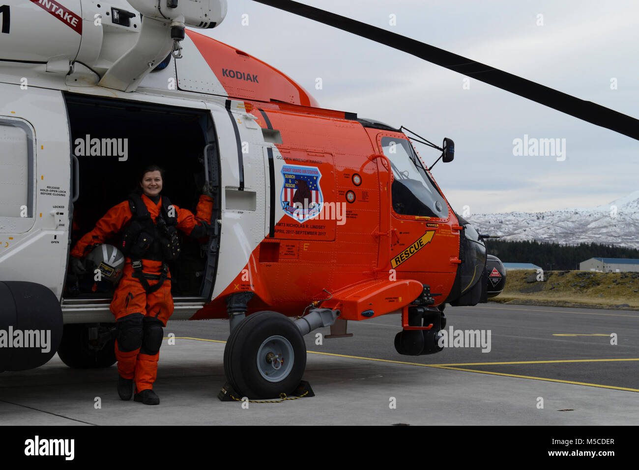 Petty Officer 2nd class Eileen am Besten, ein Aviation Maintenance Technician, steht neben einem MH-60 Jayhawk Helikopter bei Coast Guard Air Station Kodiak, Alaska, 13.02.2018. Am besten hat einen Flug Mechaniker für mehr als ein Jahr gewesen und ist ihre zweite Tour in Kodiak dienen. Us-Küstenwache Stockfoto