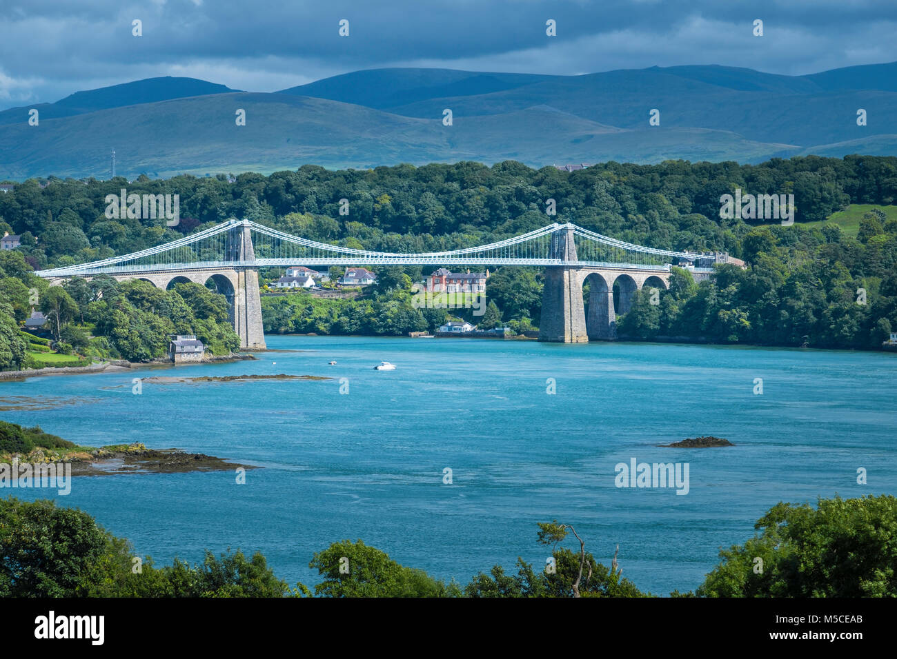 Die Menai Bridge mit Snowdonia in der Ferne. Stockfoto