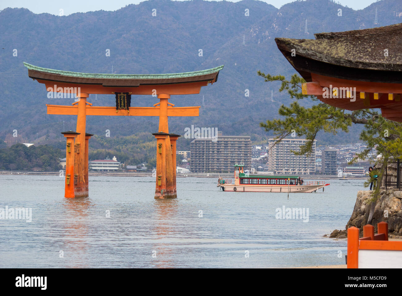 Itsukushima, auch als Miyajima bekannt, ist eine kleine Insel in der Bucht von Hiroshima. Nur offshore ist der Riese, orange Große Torii Tor. Stockfoto