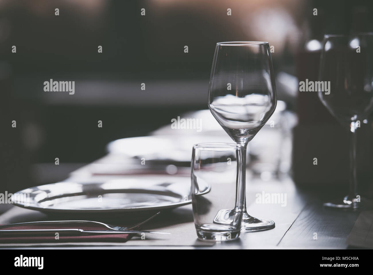 Teller und leeren Gläser auf einen Tisch in einem Restaurant für eine Feier serviert. Stockfoto