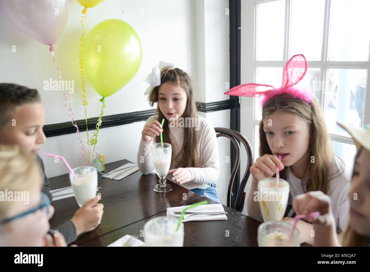 Kinder an. eine Partei trinken sind groß, Milchshakes, es gibt Ballons und Tischdekorationen Stockfoto