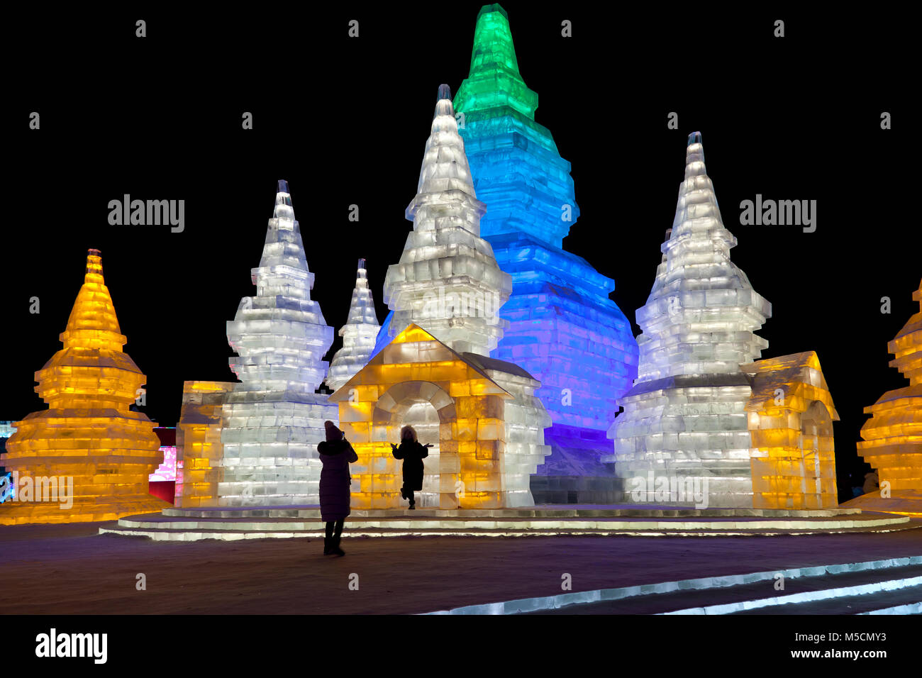 Nacht Szenen aus dem Ice Festival Harbin, Heilongjiang, China. Besucher fotografieren Vor einigen Eisskulpturen. Stockfoto