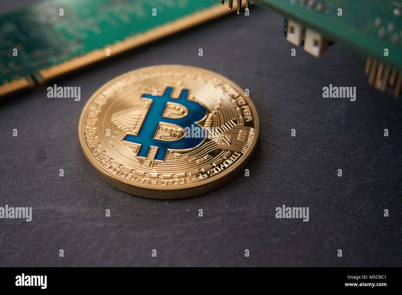 Golden bitcoin liegen auf dem Stein Fläche in der Nähe des Computer Komponenten. Cryptocurrency mining Konzept, selektive konzentrieren. Stockfoto