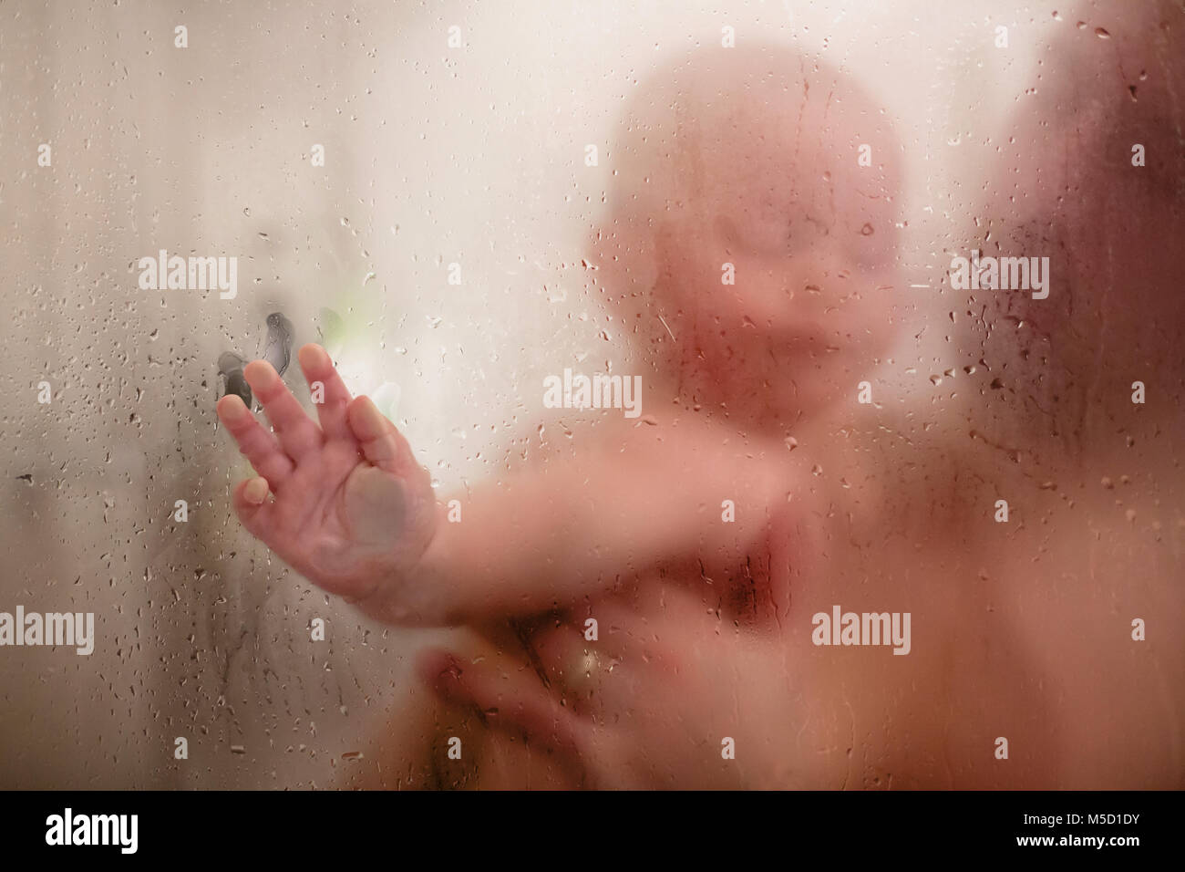 Vater und Baby boy in Dusche, Wassertropfen, Bild durch Glas Stockfoto