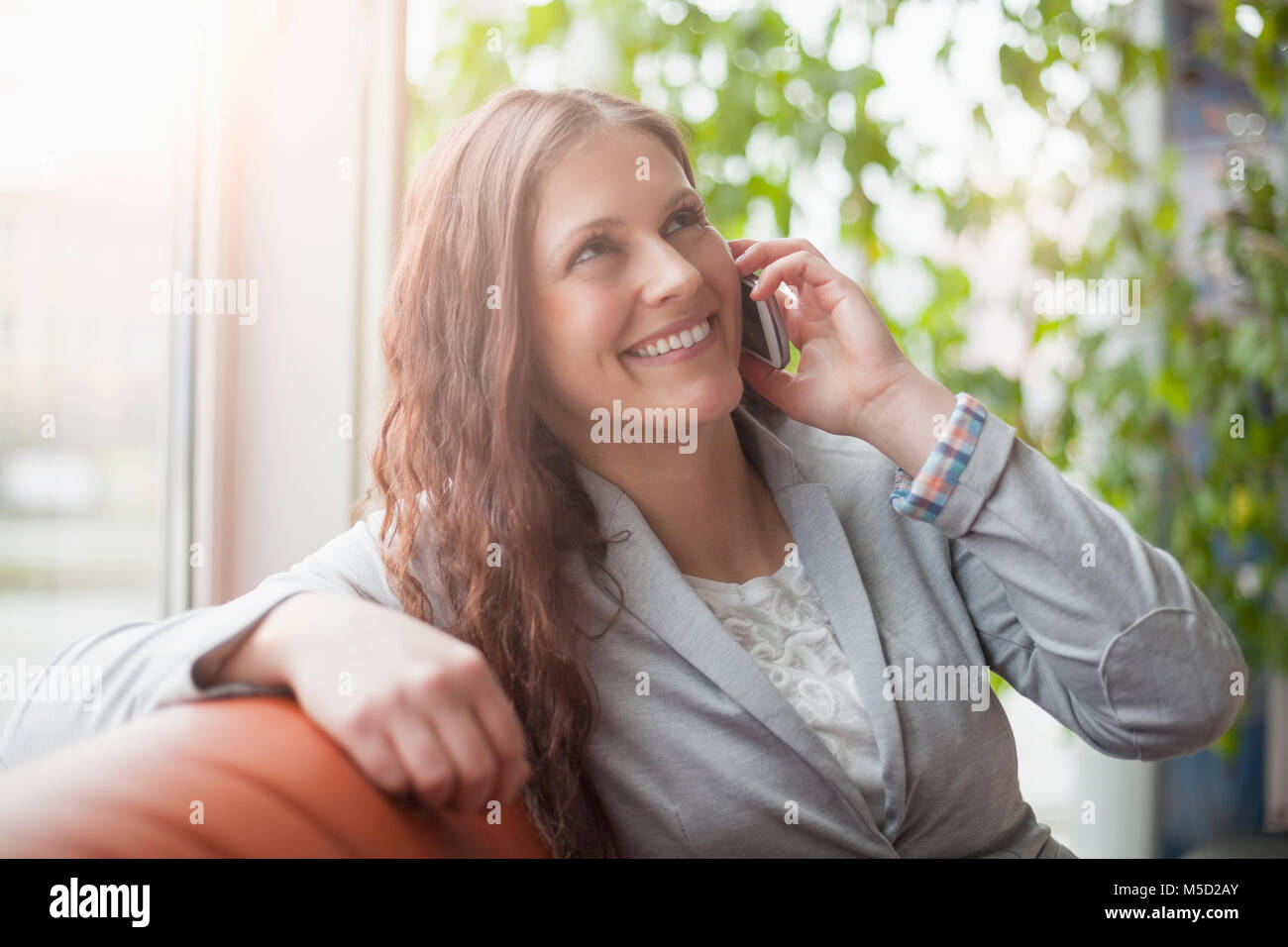 Lächelnden jungen Geschäftsfrau Gespräch am Handy im Büro Lobby Stockfoto