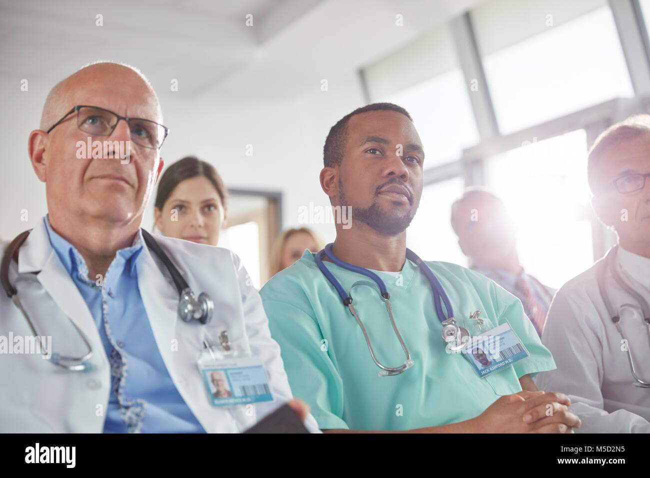 Aufmerksame Chirurgen, Ärzte und Krankenschwestern in der Sitzung hören Stockfoto
