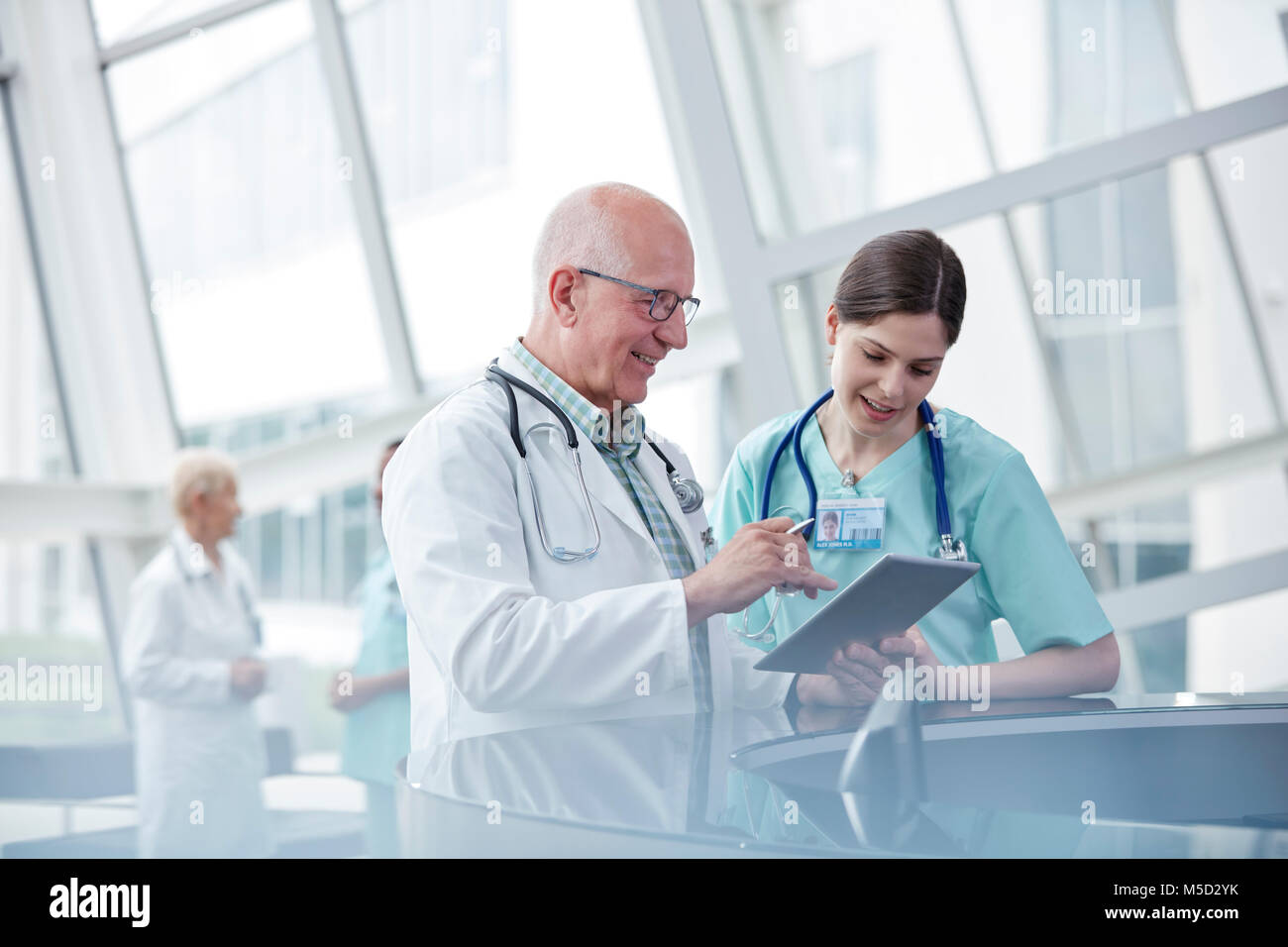 Arzt und Krankenschwester mit digitalen Tablet sprechen im Krankenhaus Stockfoto