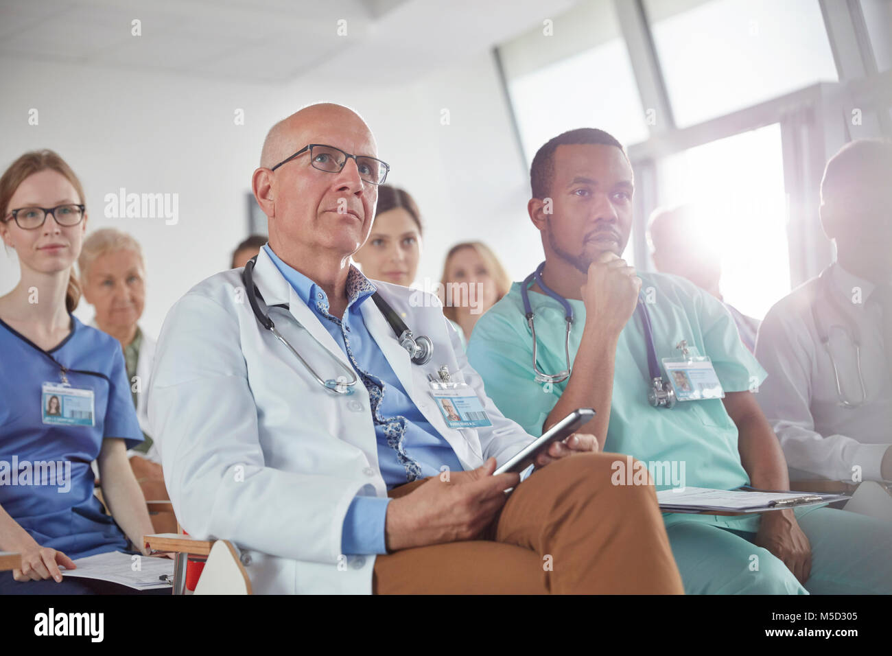 Aufmerksame Chirurgen, Ärzte und Krankenschwestern in der Konferenz zuhören Stockfoto