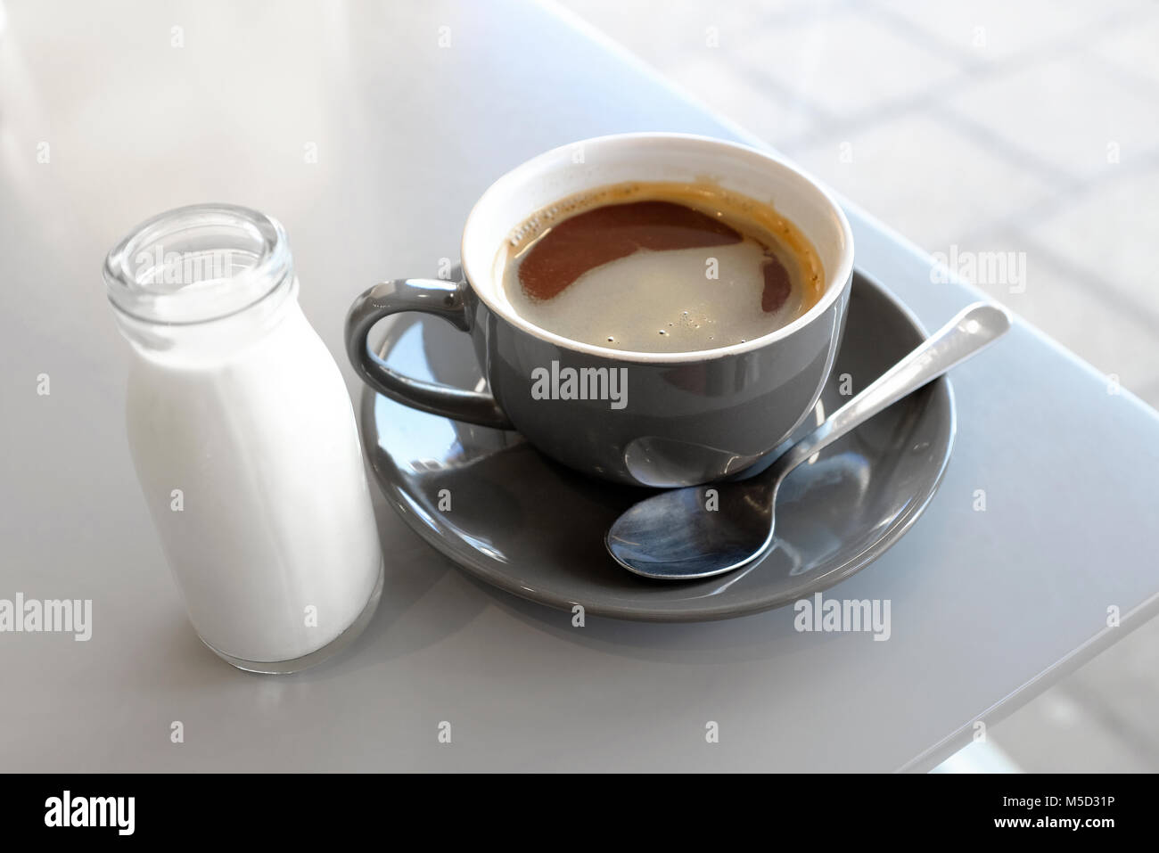 Americano Kaffee mit Milch in kleinen Glasflasche, Norfolk, England Stockfoto