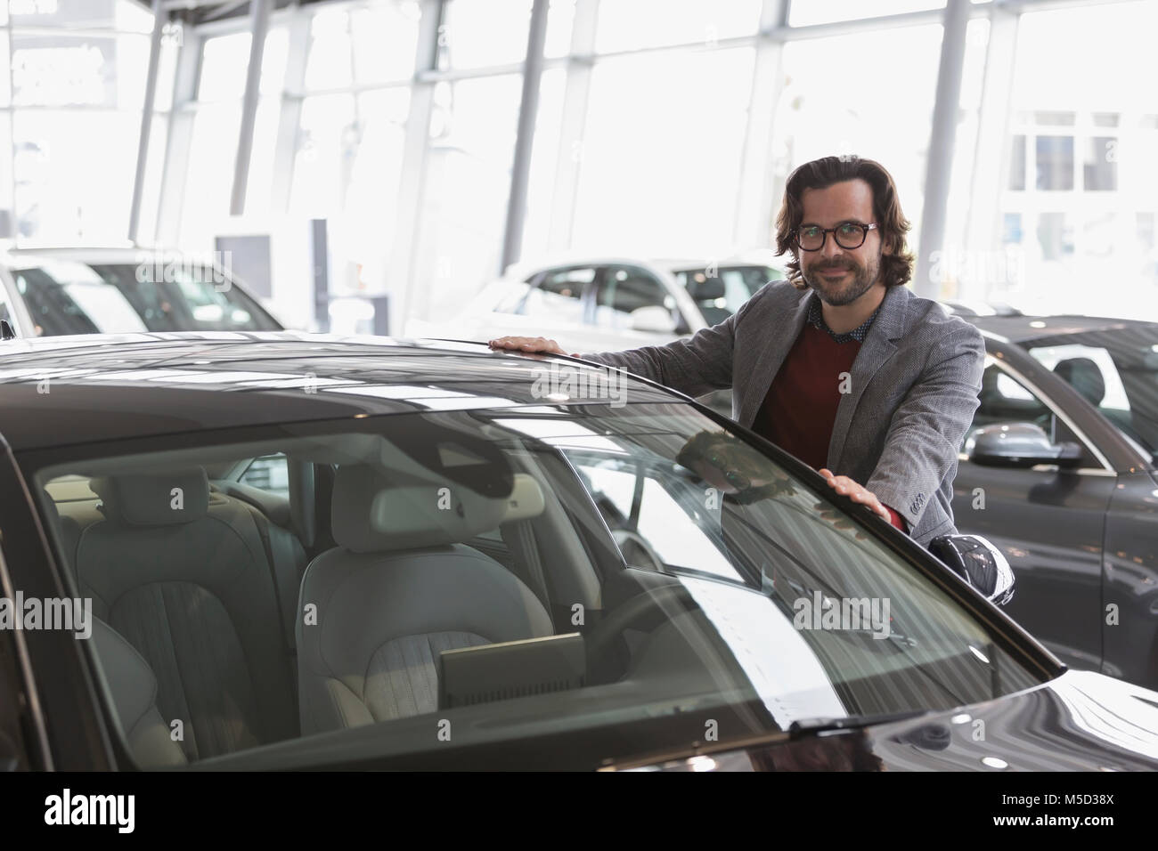 Porträt Lächeln männlichen Kunden einkaufen für neues Auto in Auto Dealership showroom Stockfoto