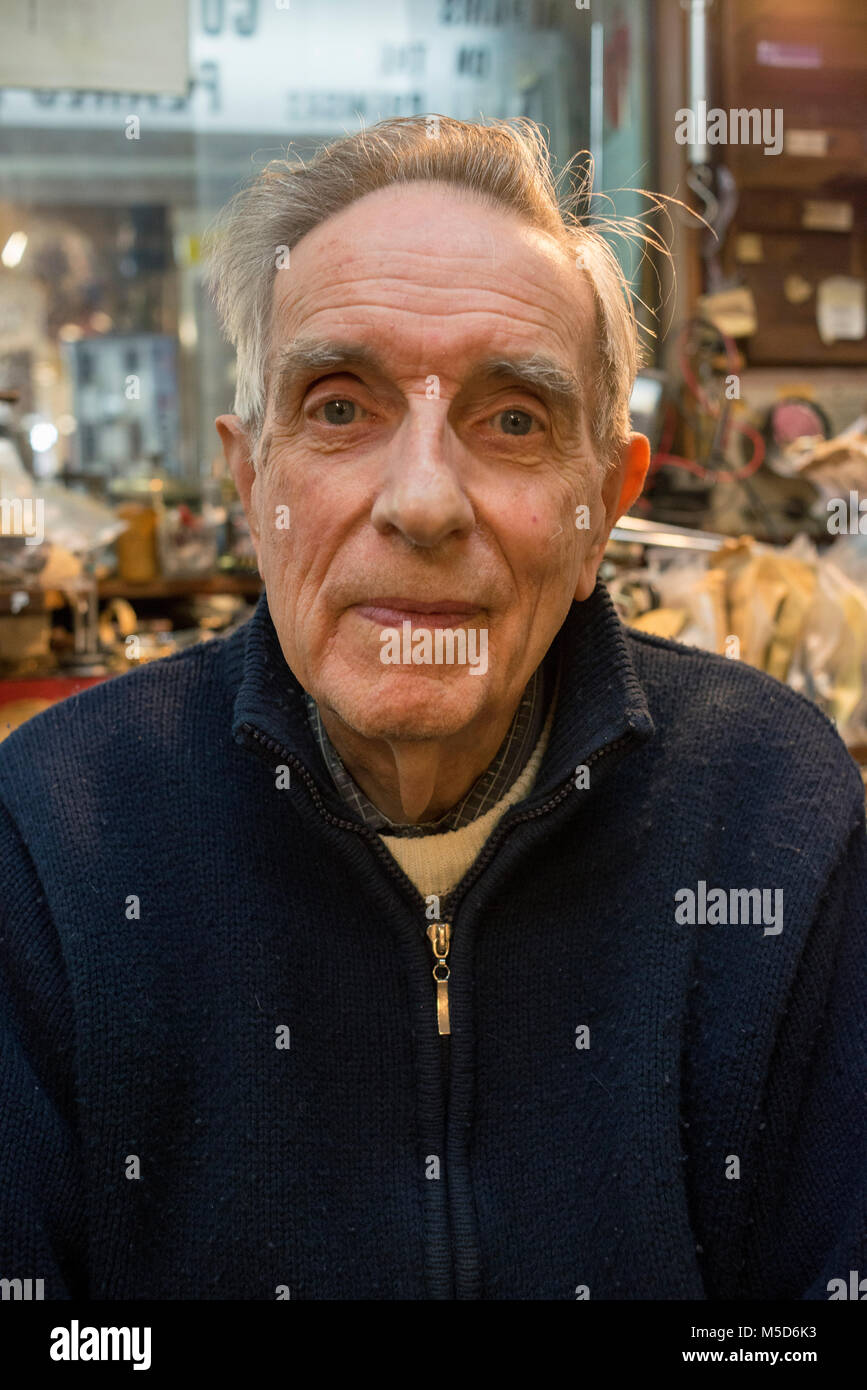 Eine alte erfahrene Watch repair Mann sitzt in seinem Shop an seiner Werkbank Stockfoto