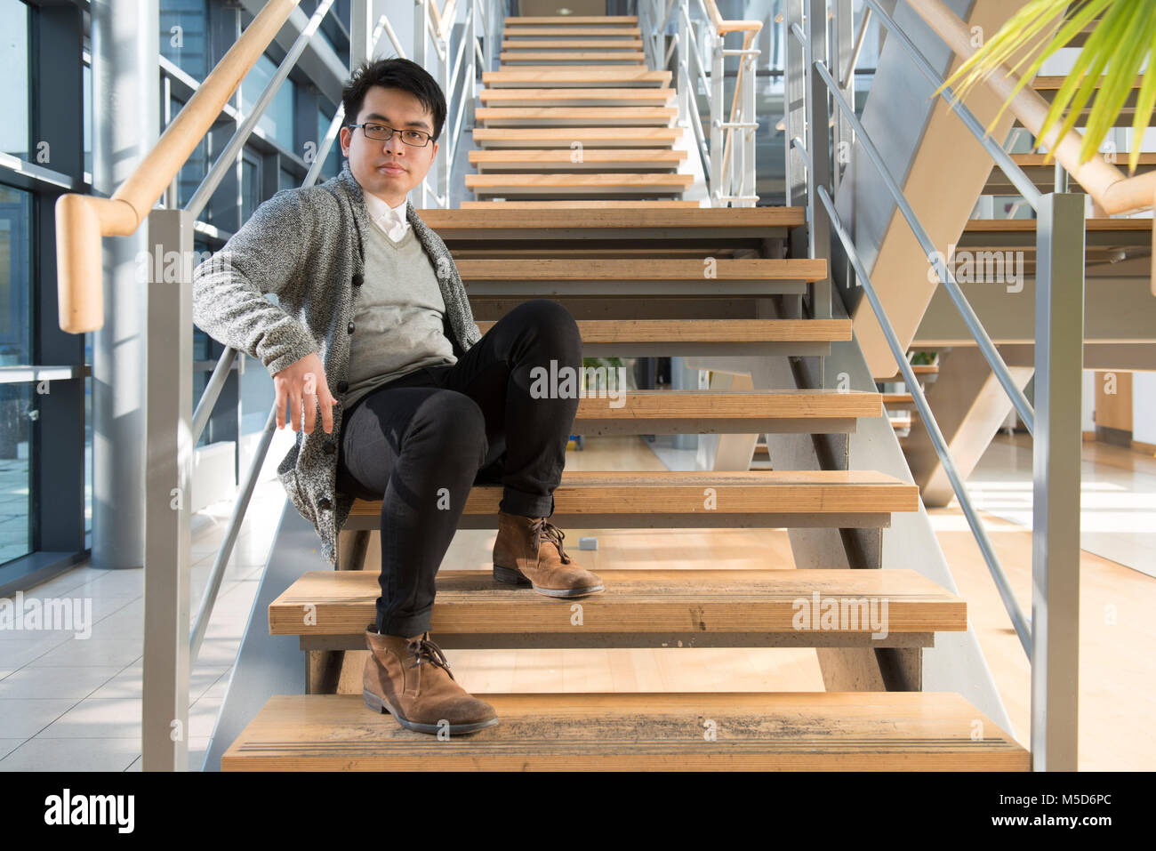 Einen jungen ausländischen Studenten steht rund um die College Campus für Porträts Stockfoto