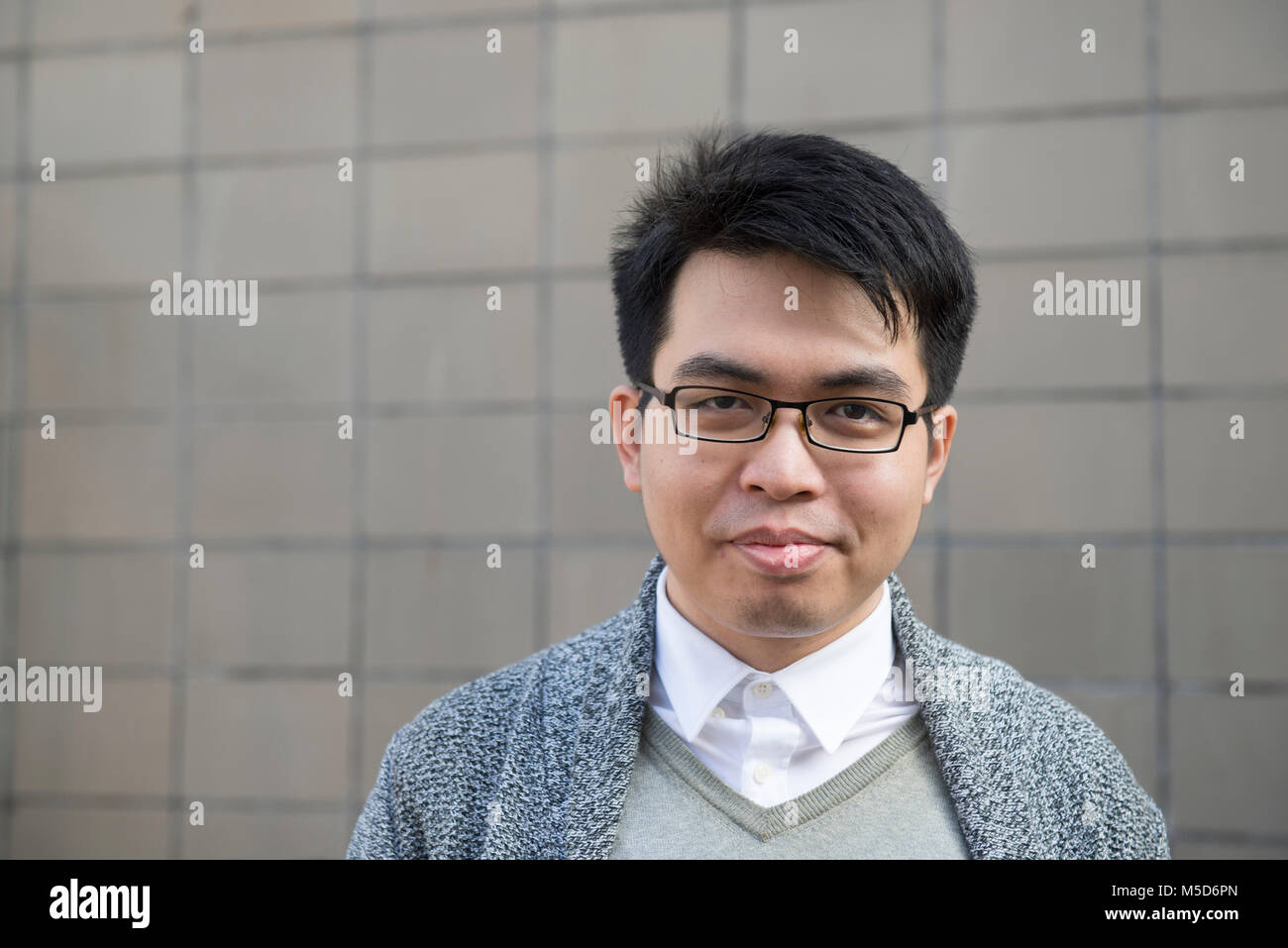 Einen jungen ausländischen Studenten steht rund um die College Campus für Porträts Stockfoto