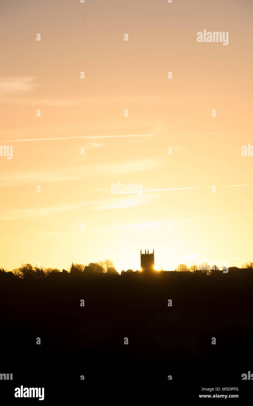 St Edward's Kirche in Wold bei Sonnenaufgang am Horizont. Silhouette. Verstauen auf der Wold, Cotswolds, Gloucestershire, England Stockfoto