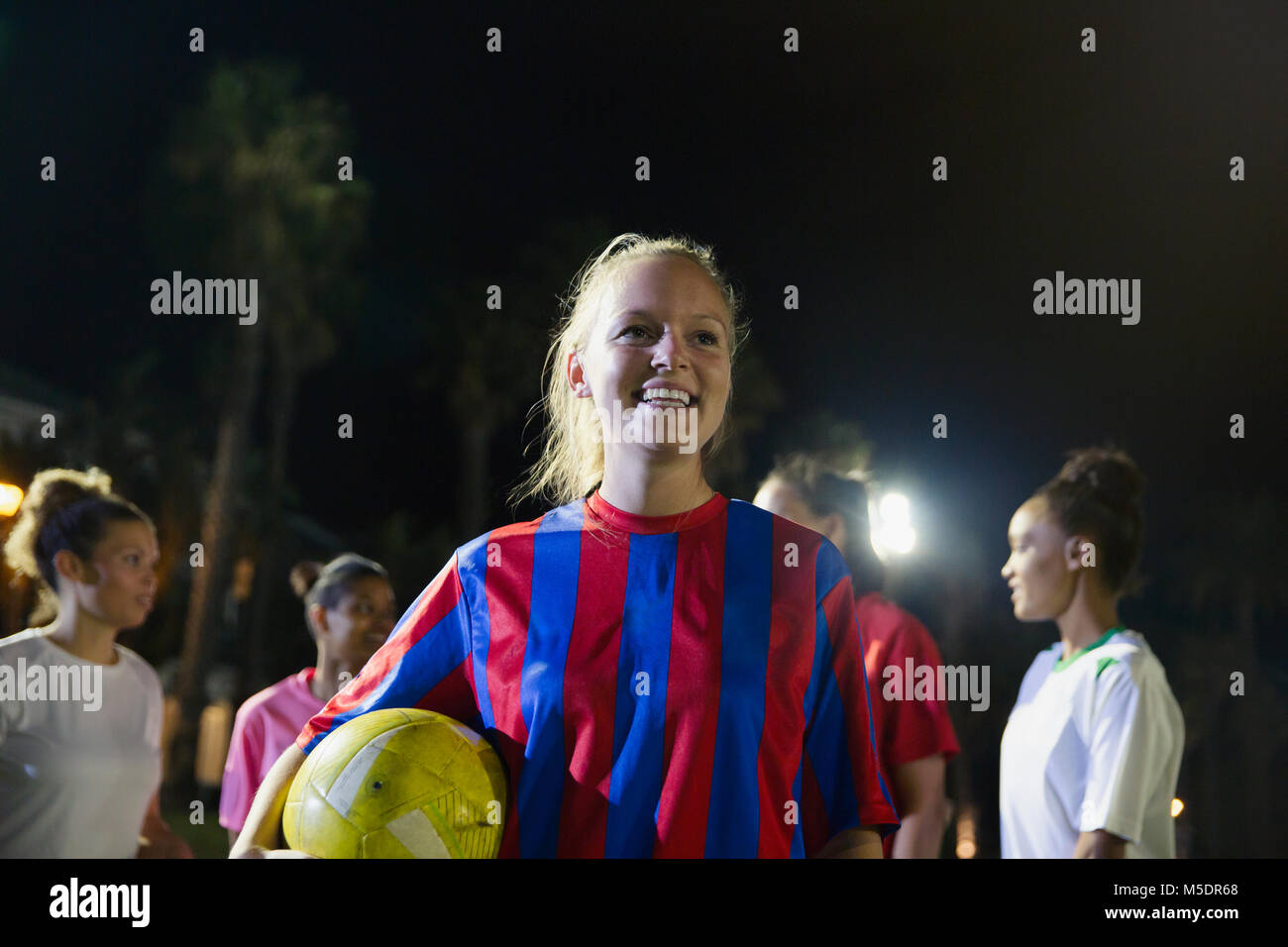Porträt Lächeln, selbstbewussten jungen weiblichen Fußball-Spieler mit Ball Stockfoto