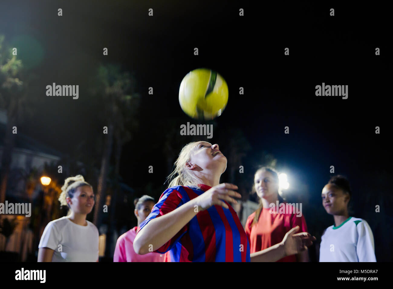 Junge weibliche Fußball-Spieler üben in der Nacht, Position die Kugel Stockfoto