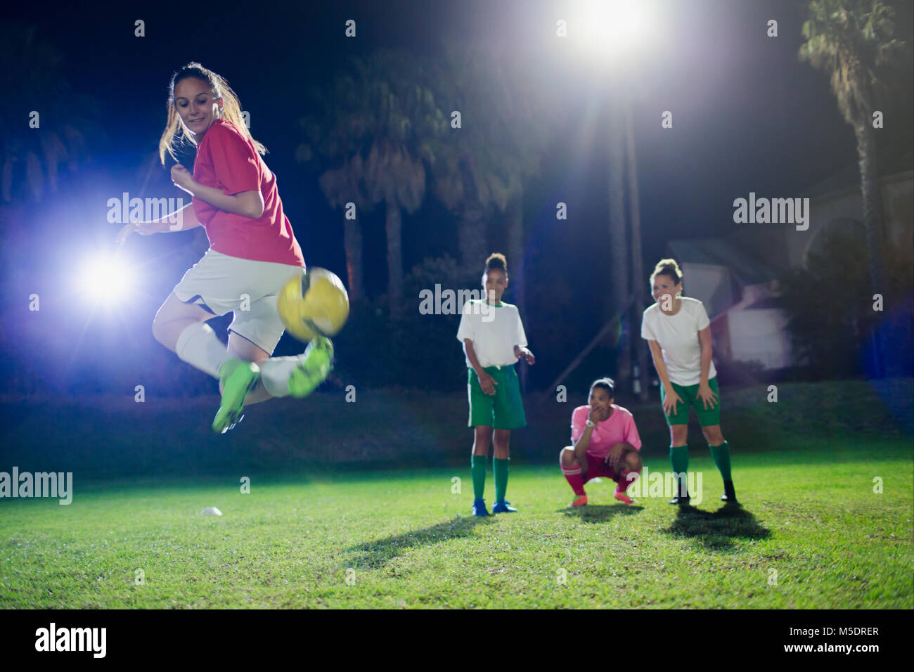 Junge weibliche Fußball-Spieler üben am Feld in der Nacht, zurück Stockfoto
