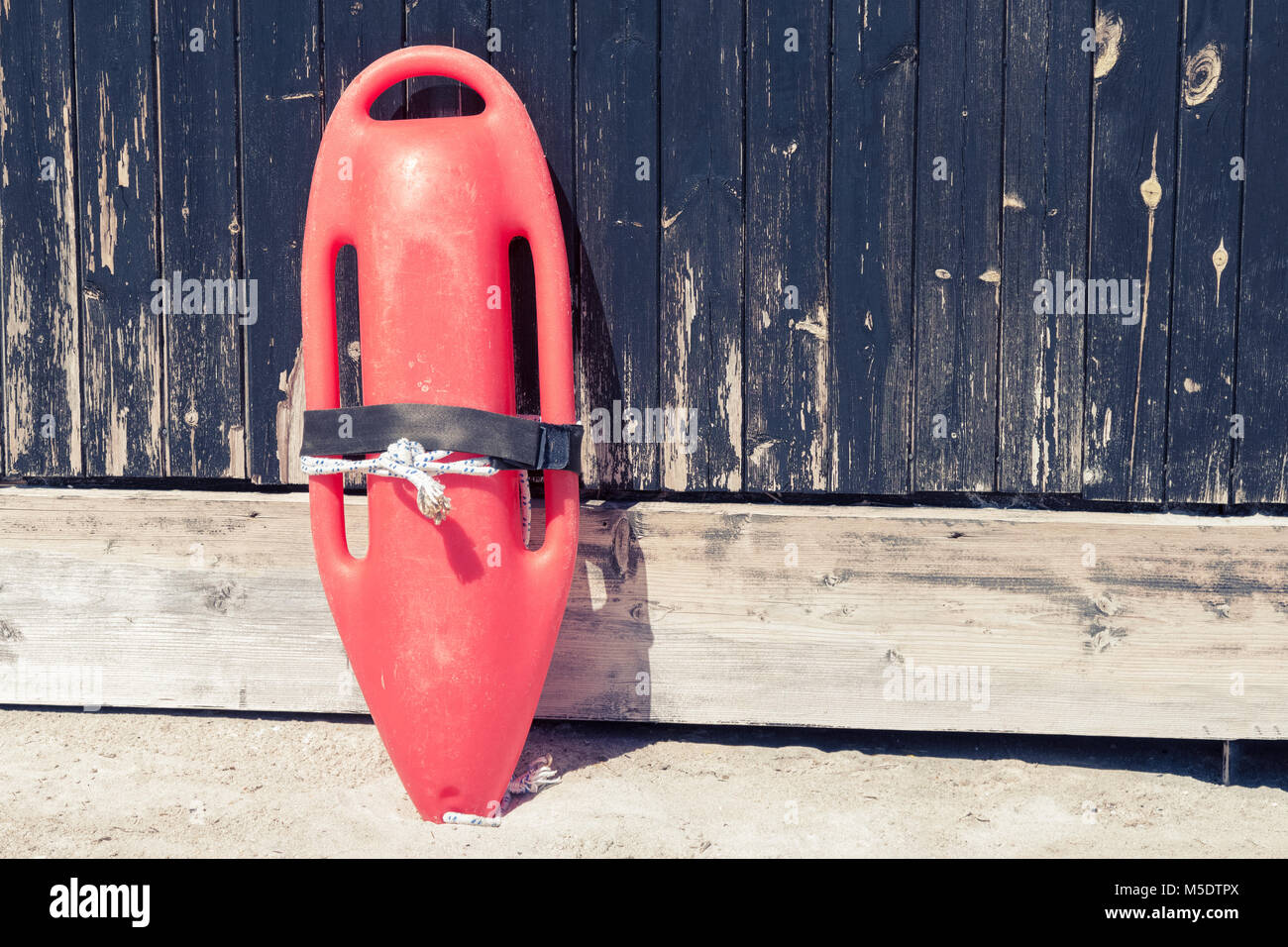 Nahaufnahme von roten Rettungsschwimmer retten können Geräte vor dem hölzernen Turm Wand am Sandstrand. Stockfoto