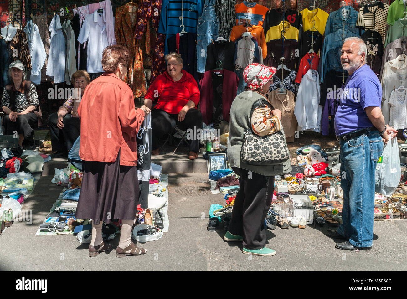 Kleine Gruppe von Menschen zu einem Stall von Kleidung an der Yerevan Flohmarkt stehen. Stockfoto