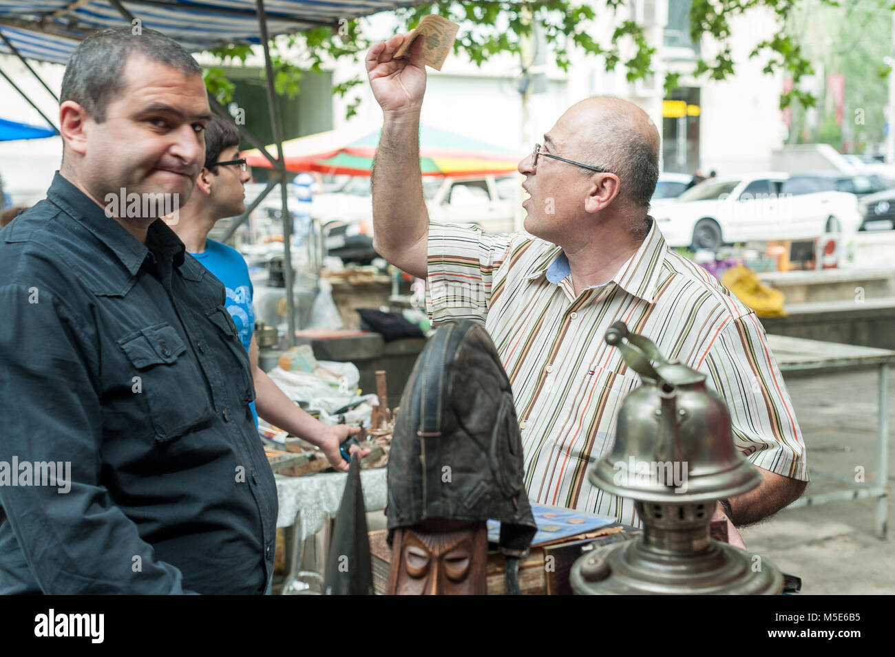 Verkäufer im Le Vernissage auf der Eriwan Flohmarkt, ist Kontrolle für gefälschte Geld. Stockfoto