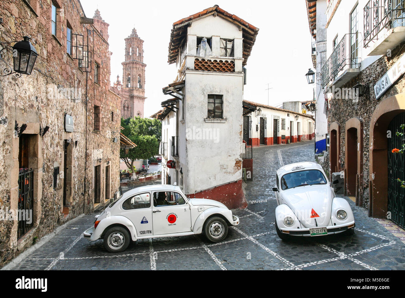 TAXCO, MEXIKO - 3. März 2012: Taxi VW Käfer im Zentrum von Taxco Bewegen auf dem schmalen Central Street in der Nähe des Zocalo in Taxco de Alarcon, Mexiko Stockfoto